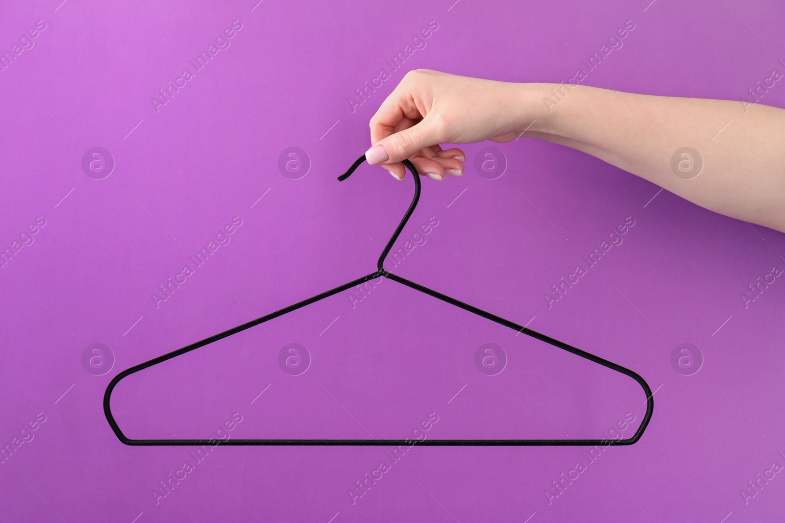 Photo of Woman holding hanger on purple background, closeup