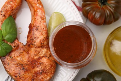 Fresh marinade, cooked fish and other products on white marble table, flat lay