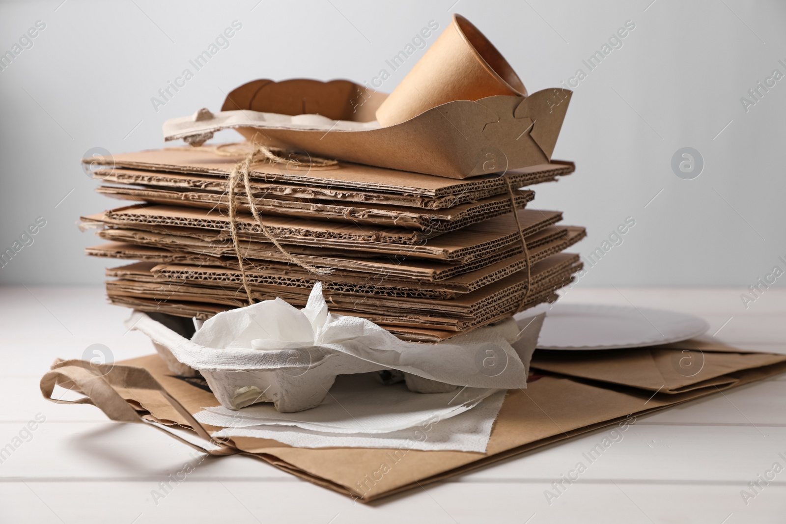 Photo of Heap of waste paper on white wooden table