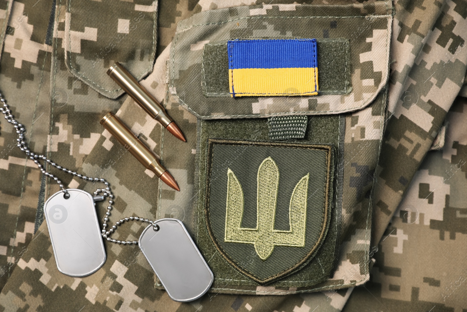 Photo of MYKOLAIV, UKRAINE - SEPTEMBER 19, 2020: Composition with Ukraine military outfit and bullets, closeup