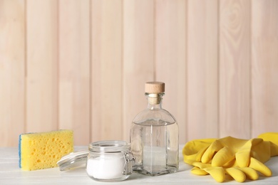 Photo of Composition with vinegar, baking soda and cleaning supplies on table