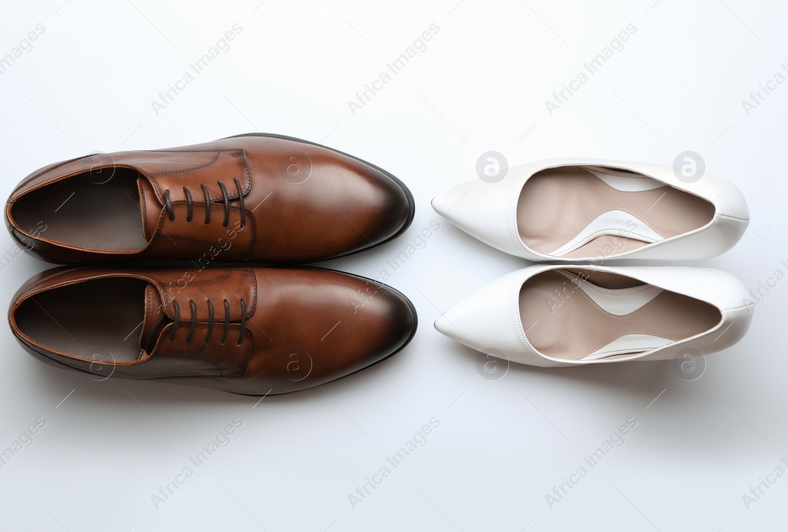 Photo of Wedding shoes for bride and groom on white background, top view