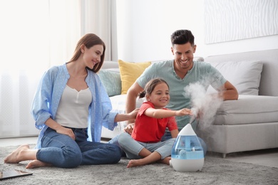 Family near modern air humidifier at home