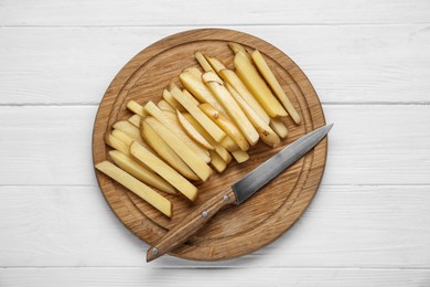 Photo of Cut raw potatoes on white wooden table, top view