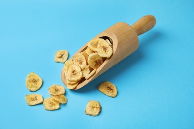 Photo of Wooden scoop with banana slices on color background. Dried fruit as healthy snack