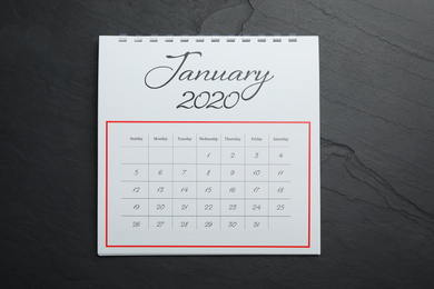 Photo of January 2020 calendar on black stone background, top view
