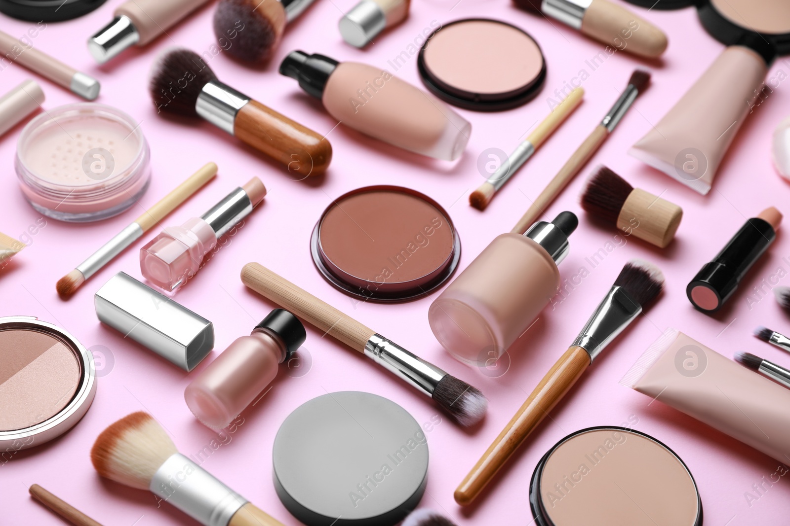 Photo of Face powders and other decorative cosmetic products on pink background
