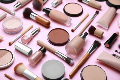 Face powders and other decorative cosmetic products on pink background