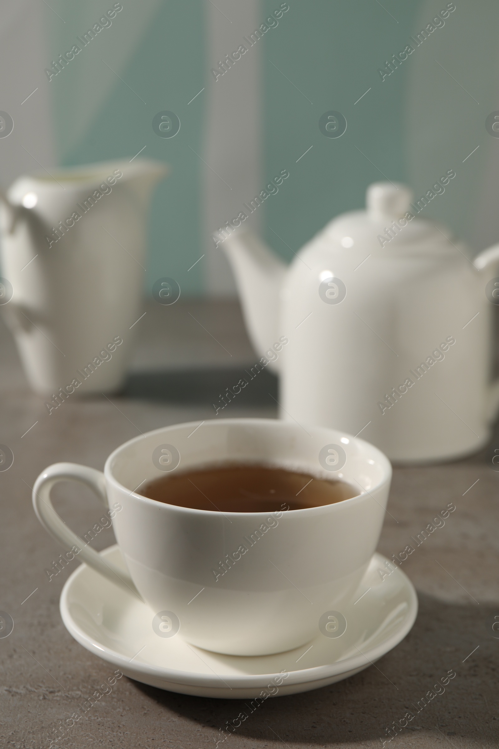 Photo of Aromatic tea in cup on gray table