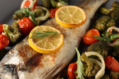 Photo of Baked fish with vegetables, rosemary and lemon, closeup