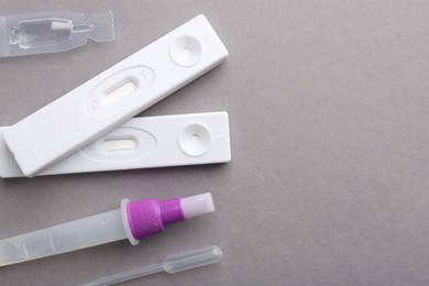 Photo of Disposable express test kits on grey background, flat lay. Space for text