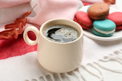 Photo of Composition with hot drink and warm plaid on white wooden table, closeup