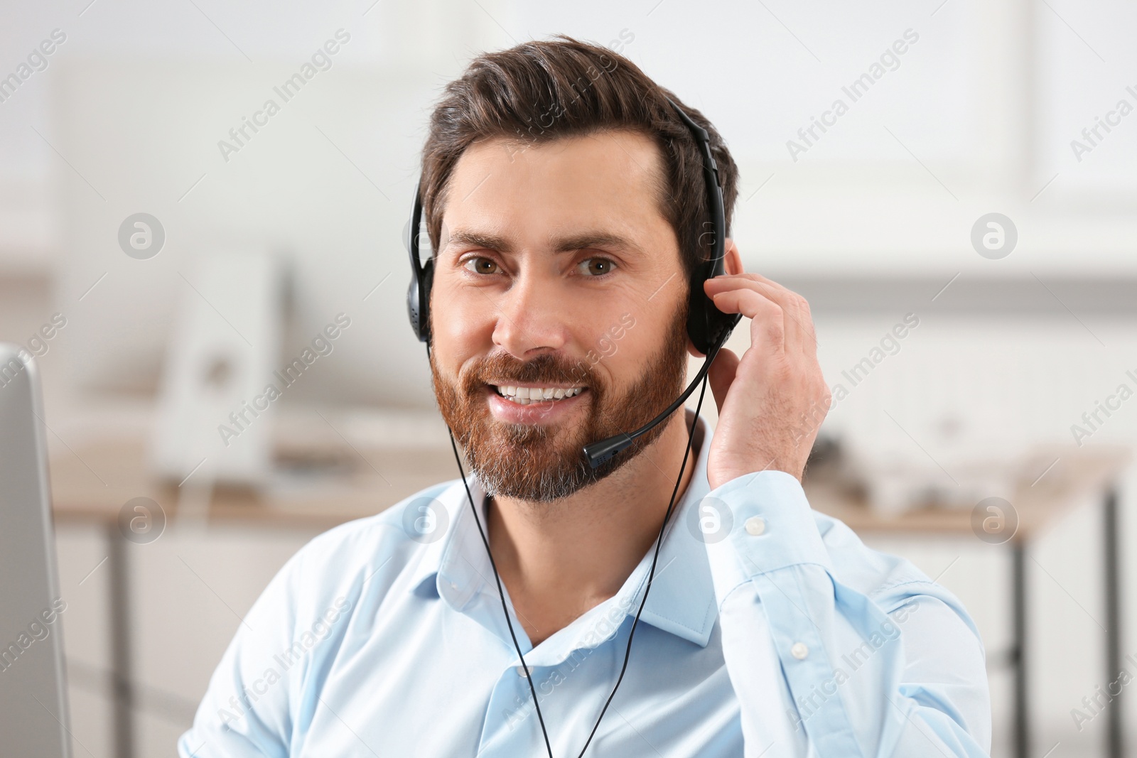 Photo of Hotline operator with headset working in office