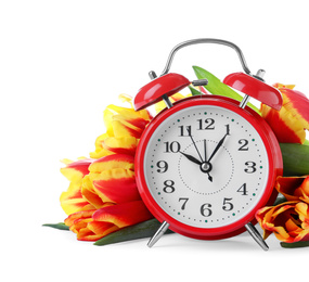 Photo of Red alarm clock and spring flowers on white background. Time change