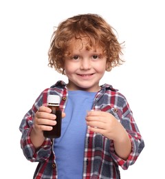 Photo of Little boy holding bottle and measuring cup with cough syrup on white background. Effective medicine
