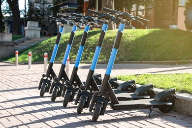 Many modern electric scooters parked on city street. Rental service