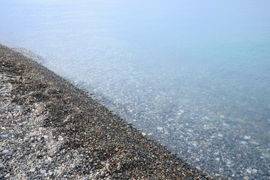 Photo of Beautiful view of sea tide on shingle beach. Summer vacation