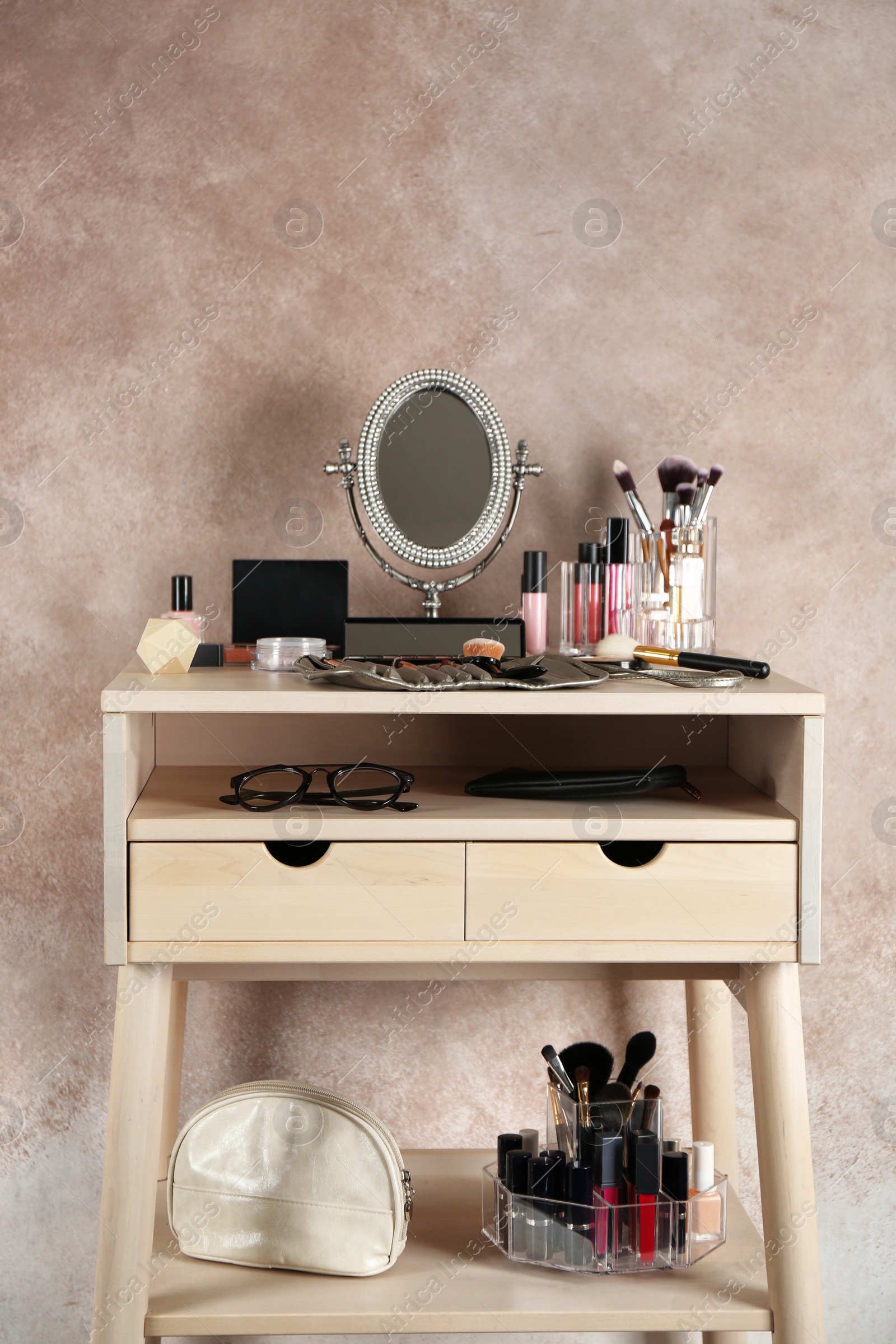 Photo of Dressing table with beauty accessories near color wall in room