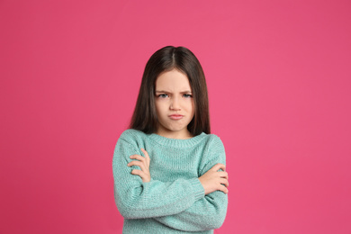 Portrait of cute little girl on pink background