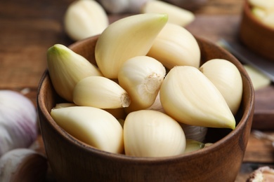 Photo of Fresh garlic in bowl, closeup. Organic product