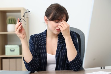 Photo of Overwhelmed woman suffering at table in office