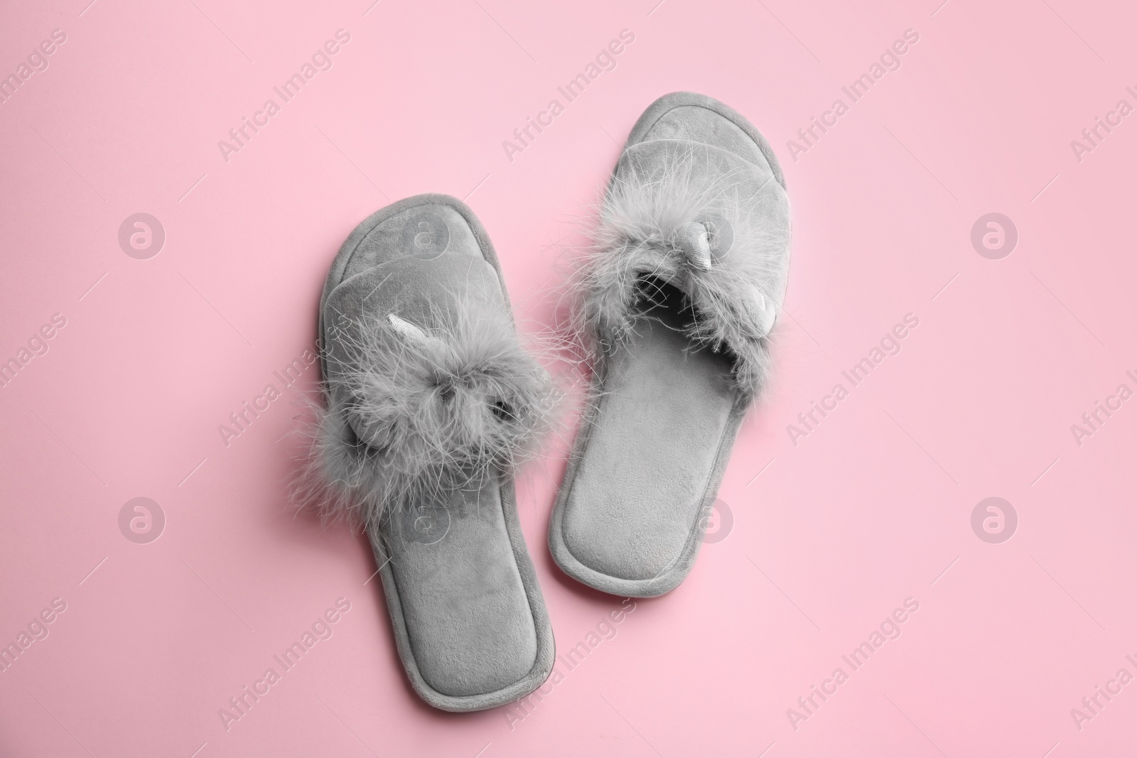 Photo of Pair of stylish soft slippers on pink background, flat lay