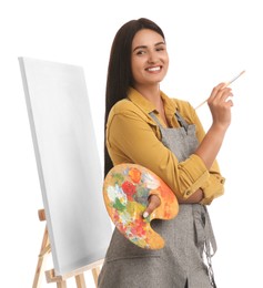 Young woman with drawing tools near easel on white background