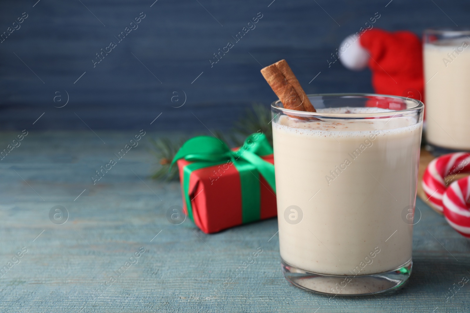 Photo of Delicious Christmas liqueur on blue wooden table, closeup. Space for text