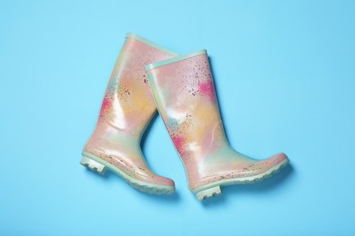 Photo of Pair of rubber boots on light blue background, top view