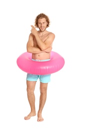 Photo of Attractive young man in swimwear with pink inflatable ring on white background