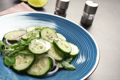 Photo of Plate with tasty cucumber salad on the table