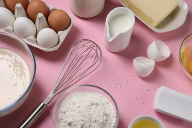 Photo of Composition with whisk and dough in bowl on pink background, above view