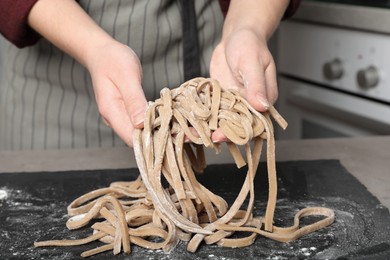 Photo of Woman making soba at table in kitchen, closeup