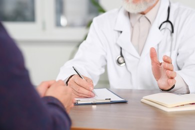 Photo of Patient having appointment with senior doctor in clinic, closeup