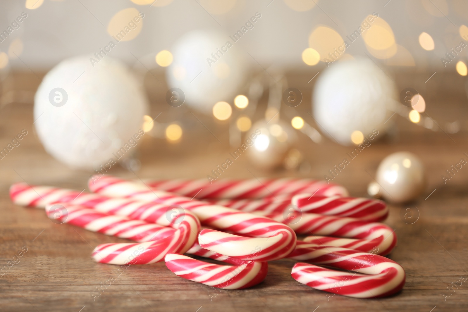 Photo of Sweet Christmas candy canes on wooden table, closeup