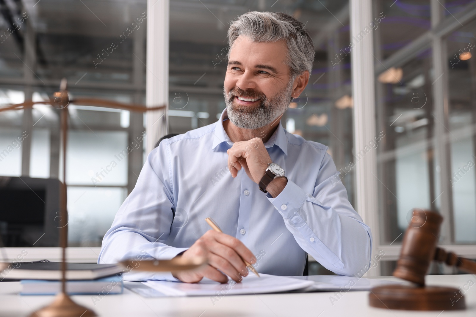 Photo of Portrait of smiling lawyer at table in office