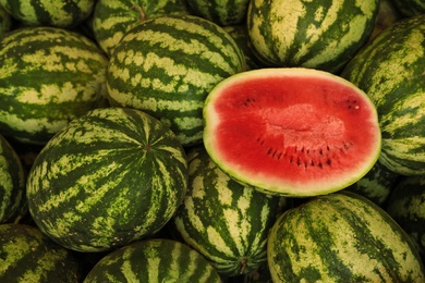 Photo of Delicious whole and cut watermelons as background, above view