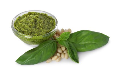 Photo of Delicious pesto sauce in bowl, pine nuts and basil leaves isolated on white