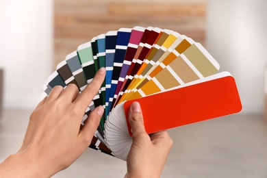 Female interior designer with color palette samples indoors, closeup