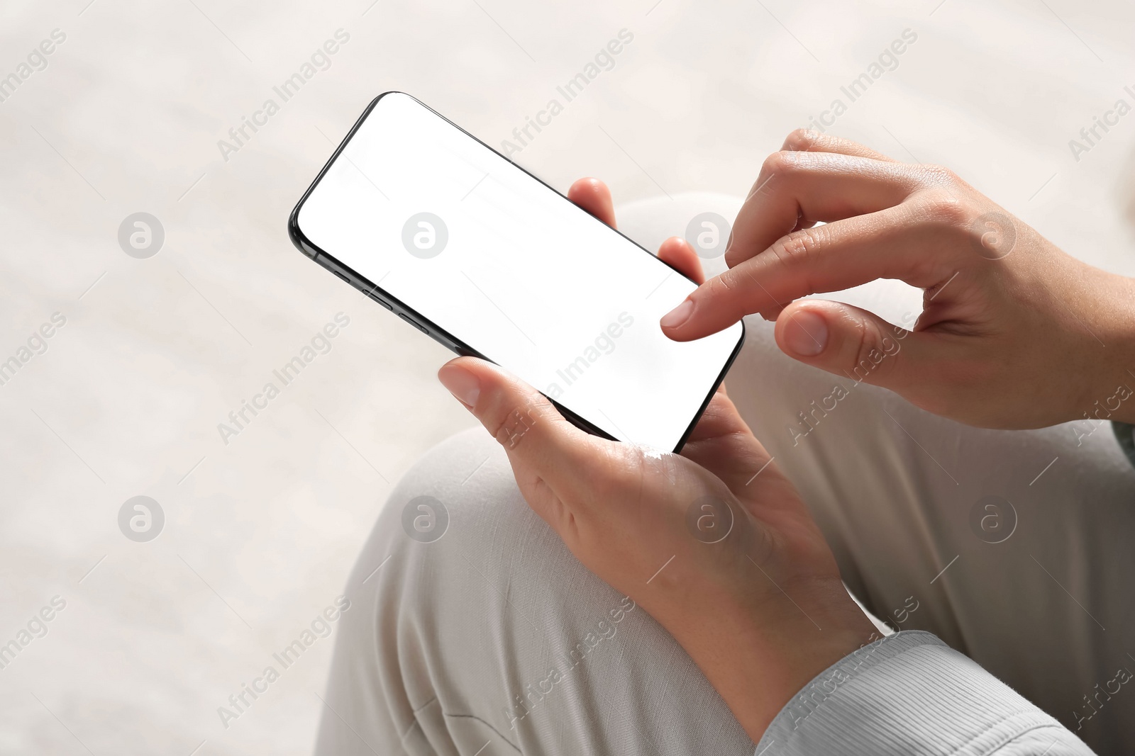 Photo of Young woman using smartphone indoors, closeup view