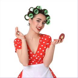 Funny young housewife with hair rollers and face powder on white background