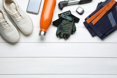 Photo of Flat lay composition with different cycling accessories on white wooden background, space for text