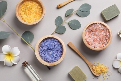 Flat lay composition with spa products and eucalyptus branches on grey background