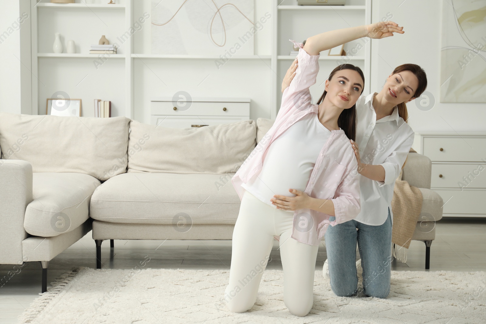 Photo of Doula working with pregnant woman at home. Preparation for child birth