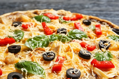Photo of Delicious homemade pizza with olives and basil on table, closeup