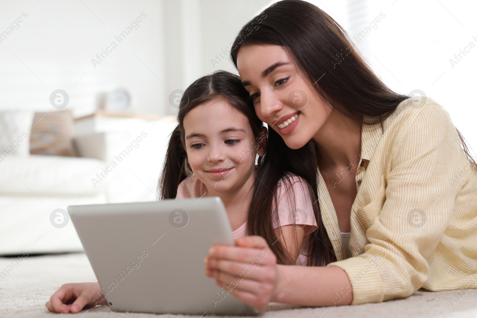 Photo of Mother and daughter reading E-book together at home