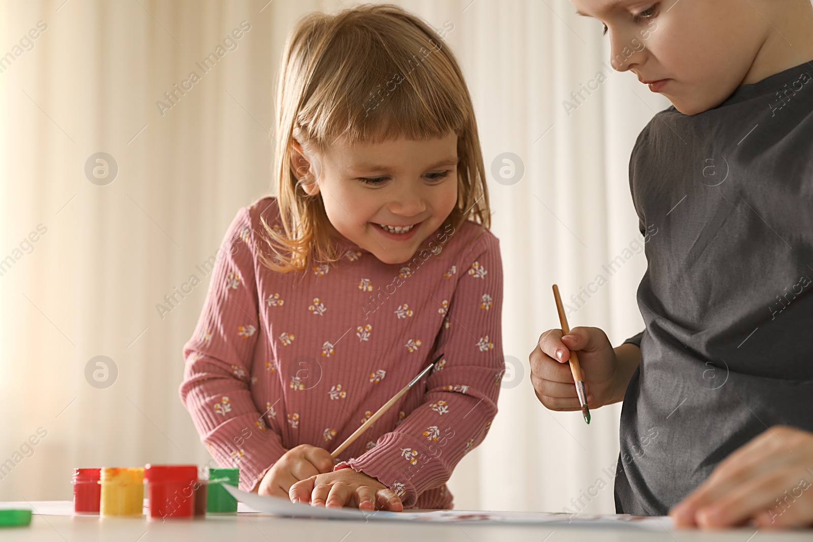 Photo of Cute little children drawing at light table indoors