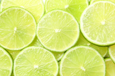 Photo of Fresh juicy lime slices as background, top view