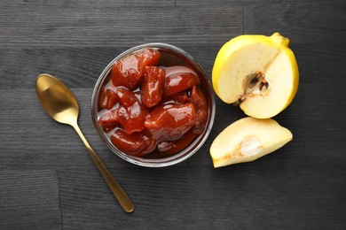 Quince jam in glass bowl, spoon and fresh raw fruits on grey wooden table, flat lay