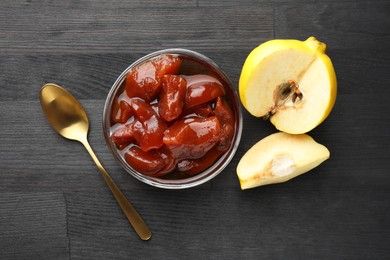 Photo of Quince jam in glass bowl, spoon and fresh raw fruits on grey wooden table, flat lay